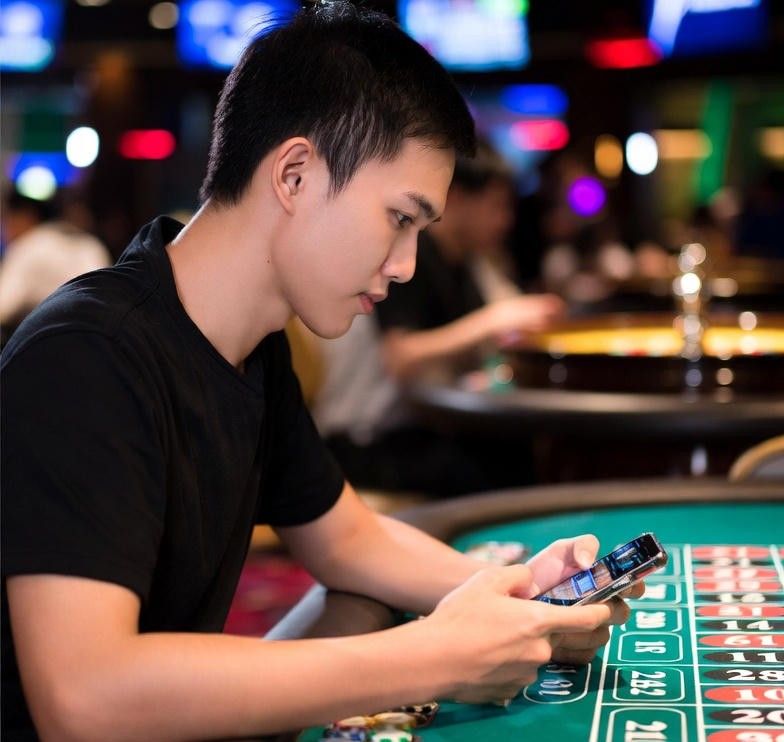 player using a smartphone to join a live roulette game